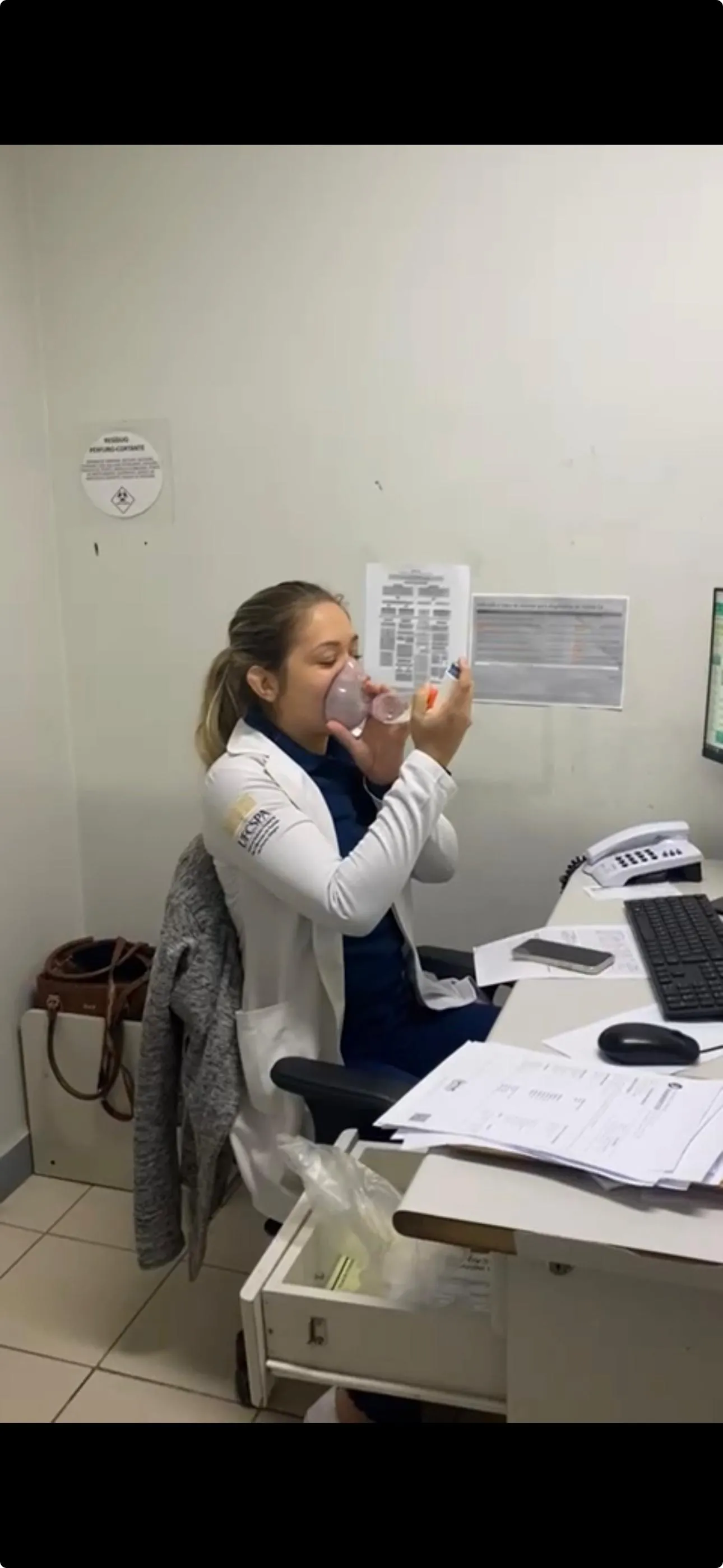 Vanessa bebendo água na sala de prescrição, durante o plantão